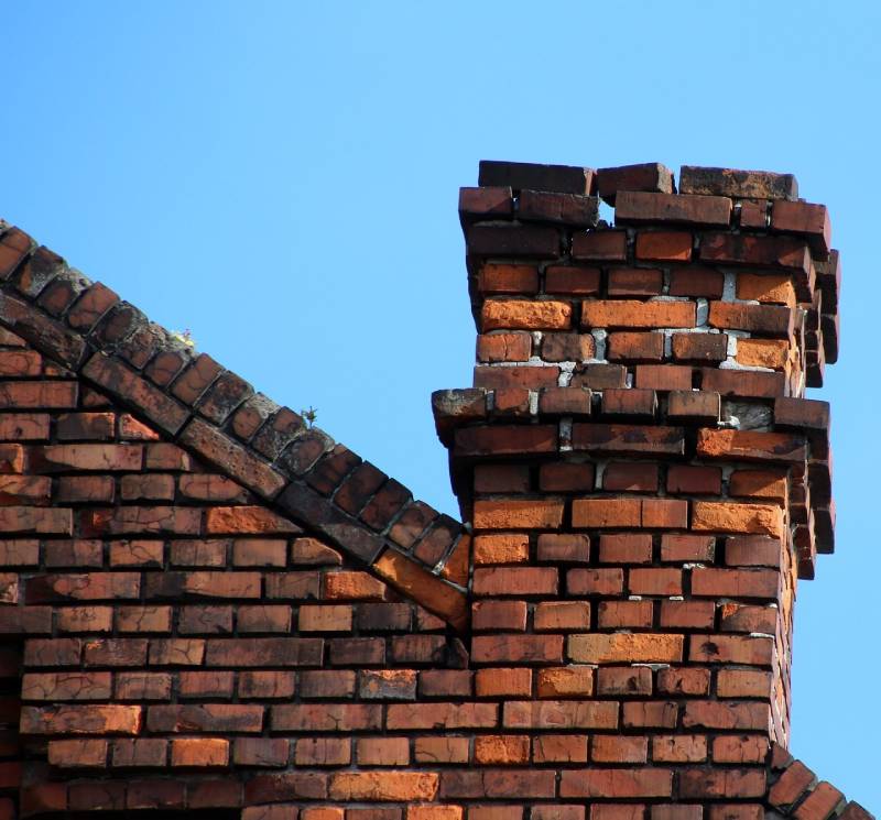 Damaged chimney on an Aventura home showing cracks and missing mortar